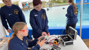 4 young woman drive their ROV in the tank